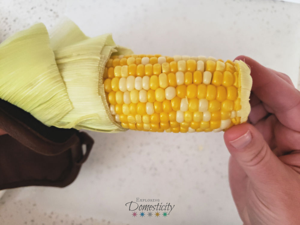 pulling no-peel microwave corn-on-the-cob out of the husk