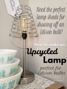 Farmhouse style wire basket shade on metal lamp next to upcycled Pyrex bowl set on burlap and lace table runner