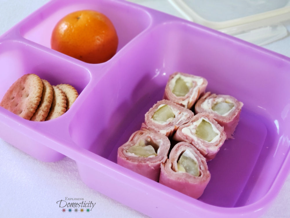 Ham pickle and cream cheese pinwheel bento box school lunch with crackers and orange
