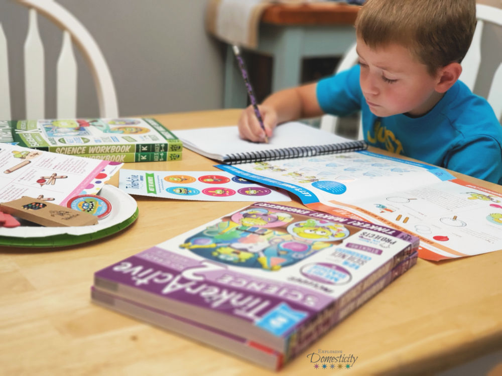 Boy at table working on TinkerActive Workbooks to get ready for school after summer vacation