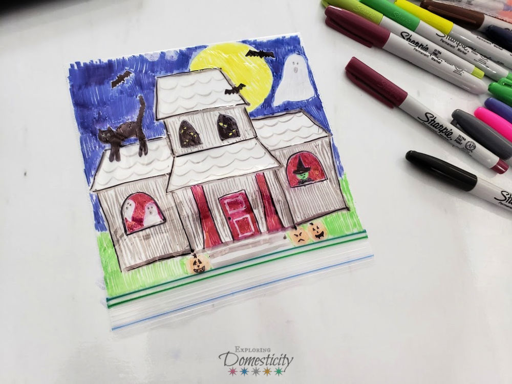Spooky Halloween scene of a haunted house on a plastic bag for flashlight craft