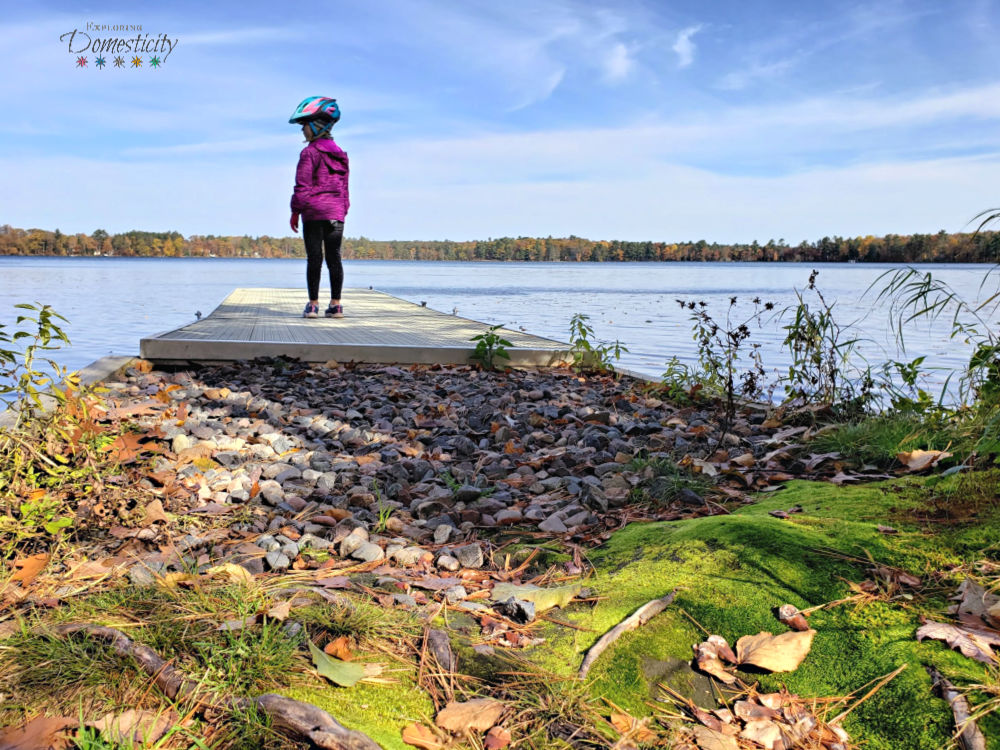 girl on dock off the lake shore in the fall