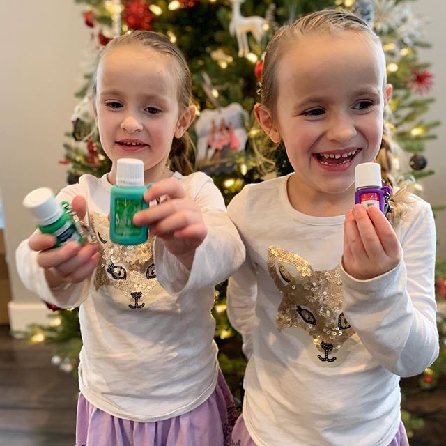 Twins holding Young Living Essential Oils