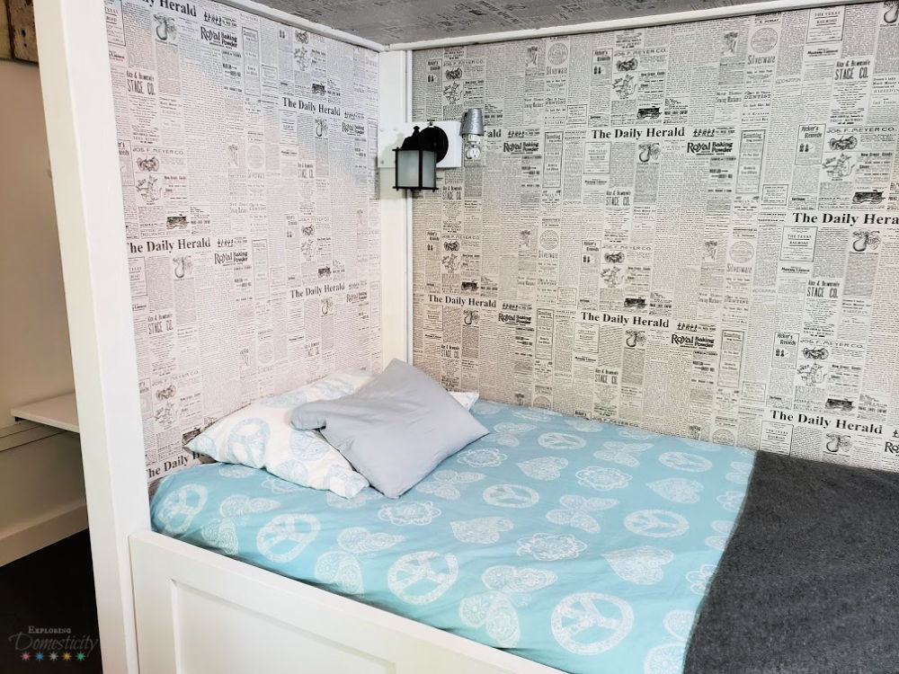 Double Bunk Beds with lights and newsprint wallpaper