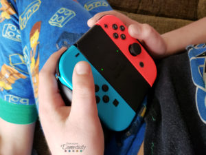 Nintendo Switch controller held by child in pajamas